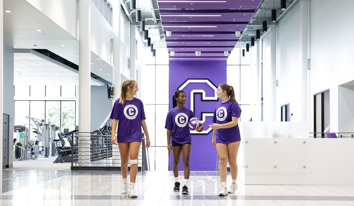 Volleyball players walk through the lobby of the SAW with the large athletic 