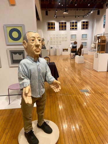 Professor Emeritus of Art Tony Plaut ’78 exhibited “An Array of Wonders: Past, Present, and Future,” at Peter Paul Luce Gallery in McWethy Hall this fall. Among the more than 100 works in the show is the self portrait figure, “Now,” seen in the foreground.