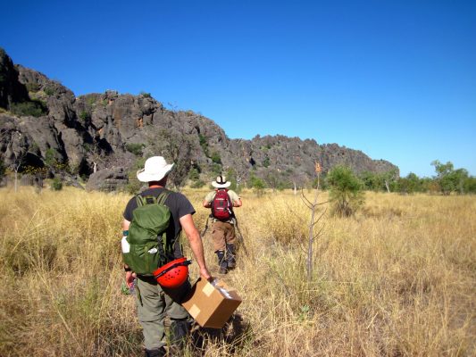 Rhawn and Australian collaborator walking to cave with equipment