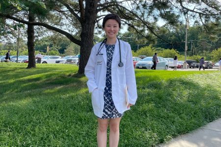 Yumeng Tao Engelking ’20 with a white doctor's coat and stethoscope