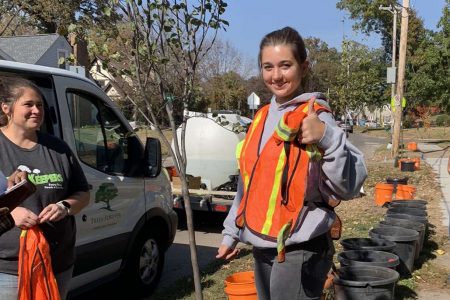 Grace giving a thumbs up near the planting location of a new tree