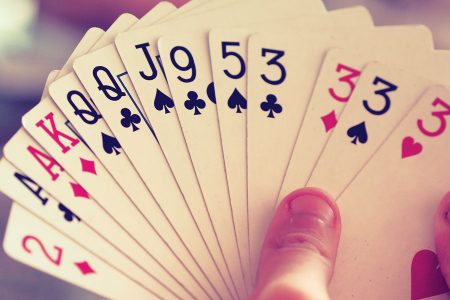 image of a hand holding playing cards