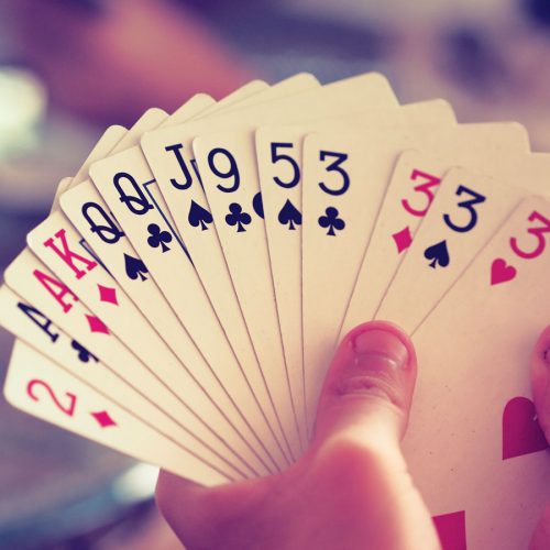 image of a hand holding playing cards