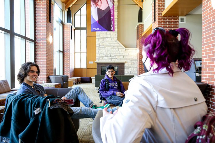 Jack Birkmeyer ’24, Jonathan Azenon ’24, and Naomi Bauer ’23 (from left) sit and talk in the lobby of the Thomas Commons, Cornell’s central gathering space.
