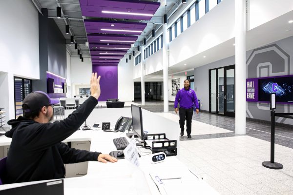 Lamb working at the check-in desk and greeting people who are coming to the SAW.