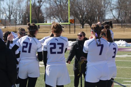 Meredith talking while team members look on from a circle