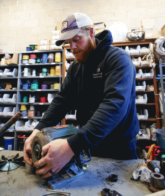 Dustin Burnett is pictured repairing a motor in the facilities warehouse