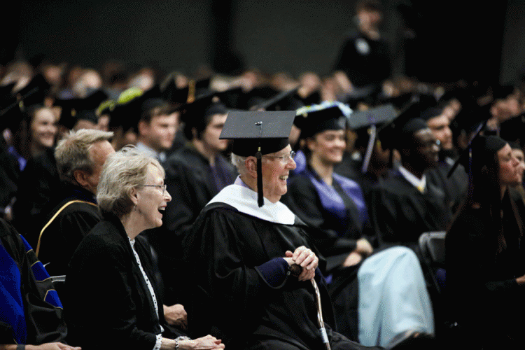 Fred Taylor '43 centered with family friend Susan McWilliams, sitting among the 2023 graduates