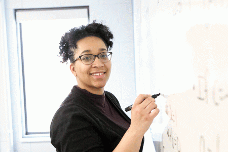 melanie king holding a dry erase marker near a dry erase board