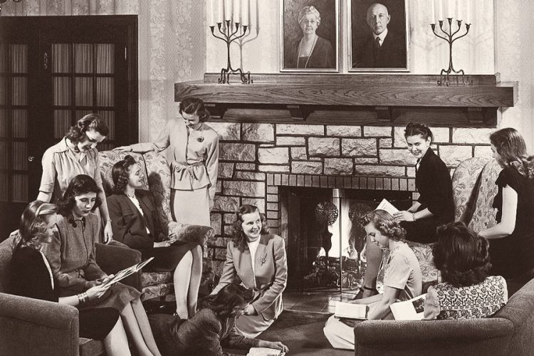 Then: 11 students gathered in Pfeiffer Hall lounge sometime in the early years after it opened in 1930. The twin portraits of the Pfeiffers no longer rest on the mantel; now, they hang on the west wall of the lounge.