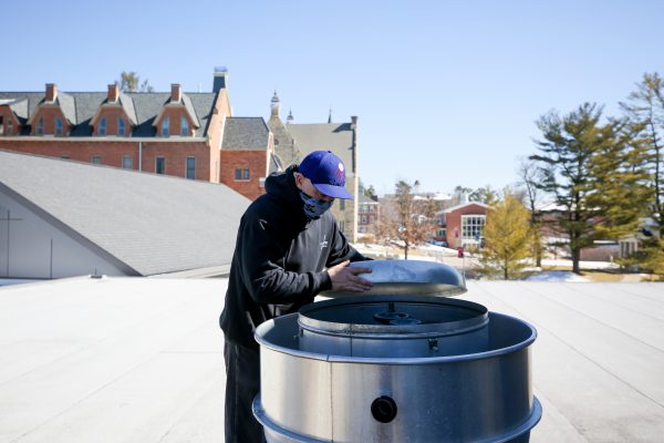 Tommy Thomas on top of the Thomas Commons roof, fixing the exhaust connected to the pizza oven.