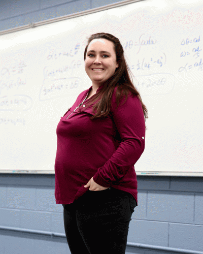 danielle grimes headshot standing in front of a whiteboard