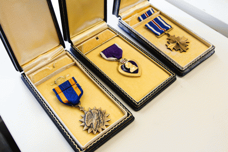 image of three medals of honor. Nelson's Air medal, purple heart, and the distinguished flying cross,