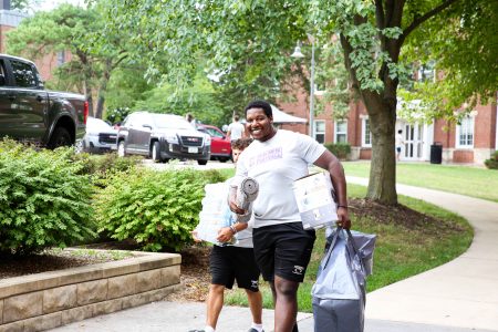 Senior football player Jacob Baggs is all smiles despite the heat as he and his fellow Cornell student-athletes help move students into their residence halls. Photo by Marketing Media Specialist Megan Amr.