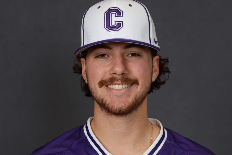 Jack smiles for a photo wearing a Cornell baseball cap and a purple jersey.