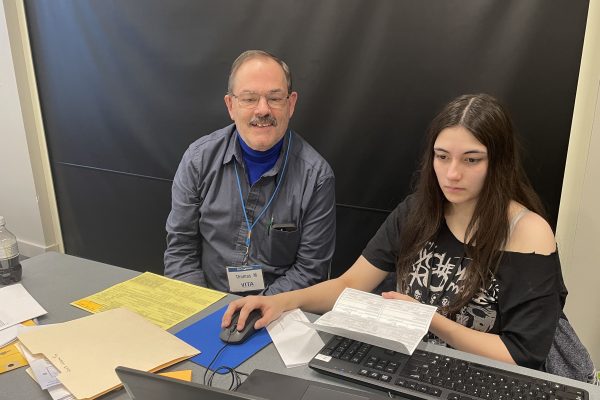 Sophomore Meena Barua (right) helps prepare a tax return for a client alongside VITA's site coordinator Tom Miller.