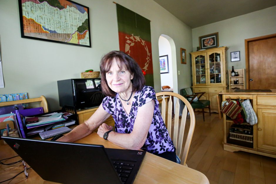 Carolyn Enns works at her living room table.