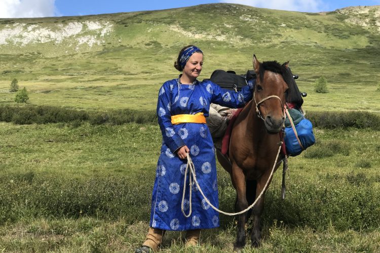 Julia Clark ’06 in traditional dress with a horse in Mongolia.