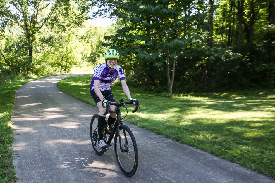 Craig Allin rides his roadbike on a paved trail.