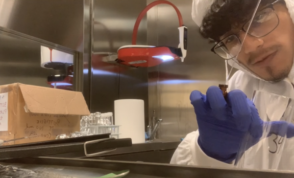 Student holding up science equipment in front of the camera