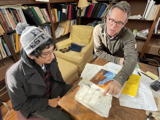 Cornell College senior Jonathan Azenon (left) and Professor of Geology and lead researcher Rhawn Denniston look at a stalagmite sample. 