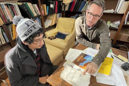 Cornell College senior Jonathan Azenon (left) and Professor of Geology and lead researcher Rhawn Denniston look at a stalagmite sample.