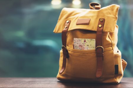 Golden backpack with a map sticking out of a pocket