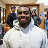 Bryce Stevens in hoodie witih several of his posse students behind him