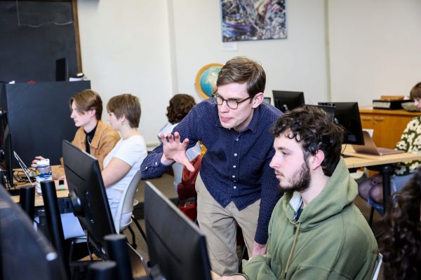 Professor describes what's happening on the screen of a computer to a student.