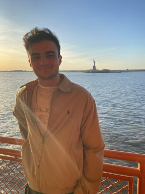 Aras Yilmaz with water and the Statue of Liberty behind him