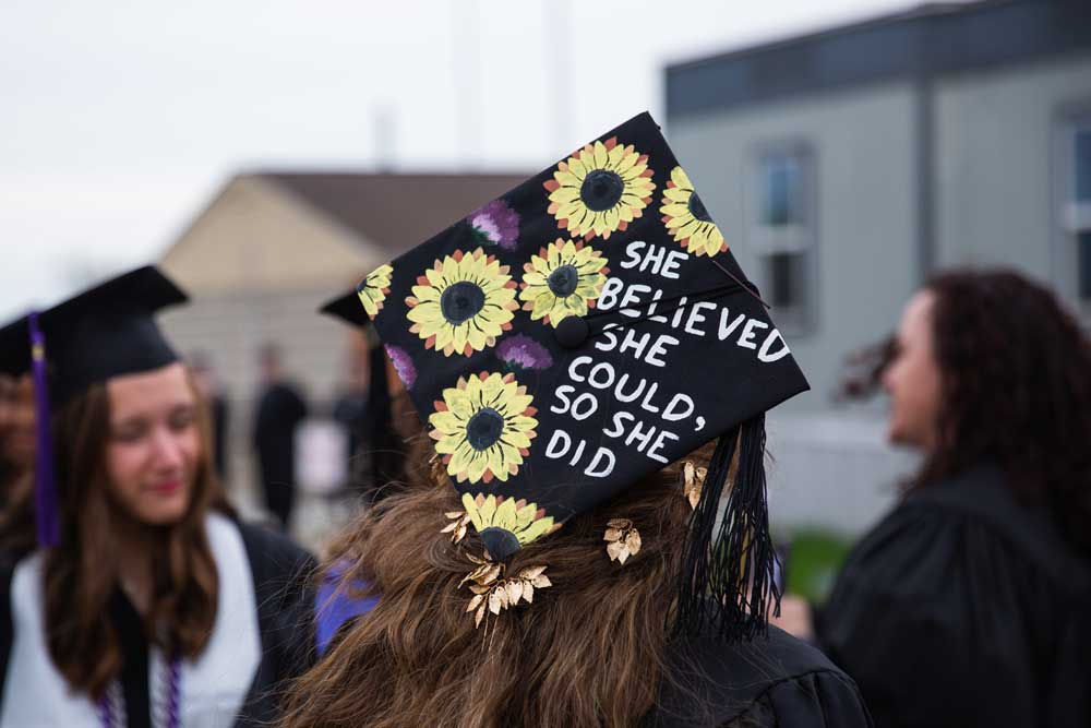 Mortarboard decorated with sunflowers and the words She believed she could, so she did