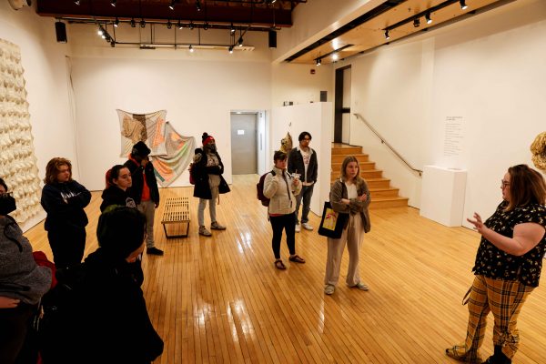 Class listens to an instructor in the Luce Art Gallery