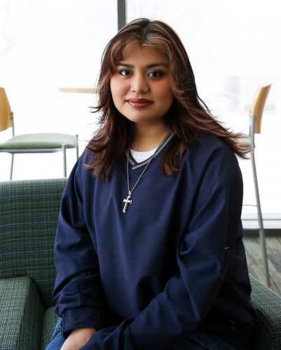 Shirley Romero Carreon ’25 is seated in a Russell Science Center lounge. She is from Dallas, Texas, and is president of Gente, the campus Latine group.