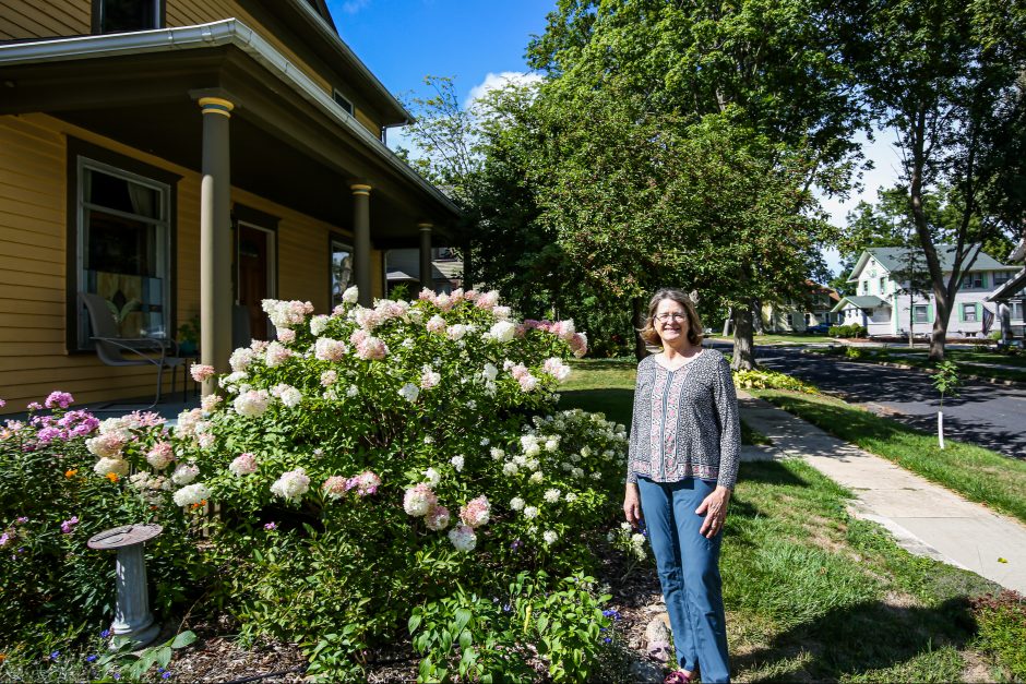 Suzette Astley stands in the front yard of her historic home in Mount Venron, Iowa