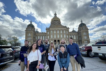 Students pose for photo outside the State Capitol building.