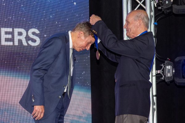 A man puts a medal around Hilmers' neck during the ceremony.