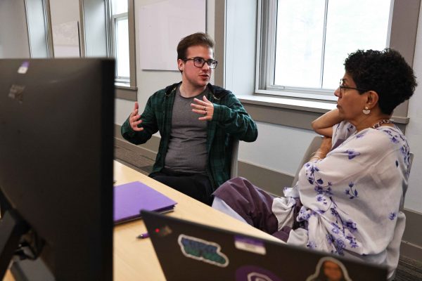 enior Jake Vuolo sits in front of computer screens with Professor Santhi Hejeebu.