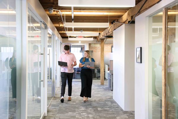 Kamrath and Seastrom walk down the hallway inside Northwest Mutual's Cedar Rapids office.