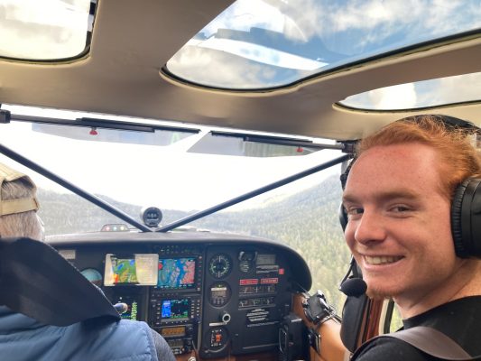 Student in the front seat of a small plane.