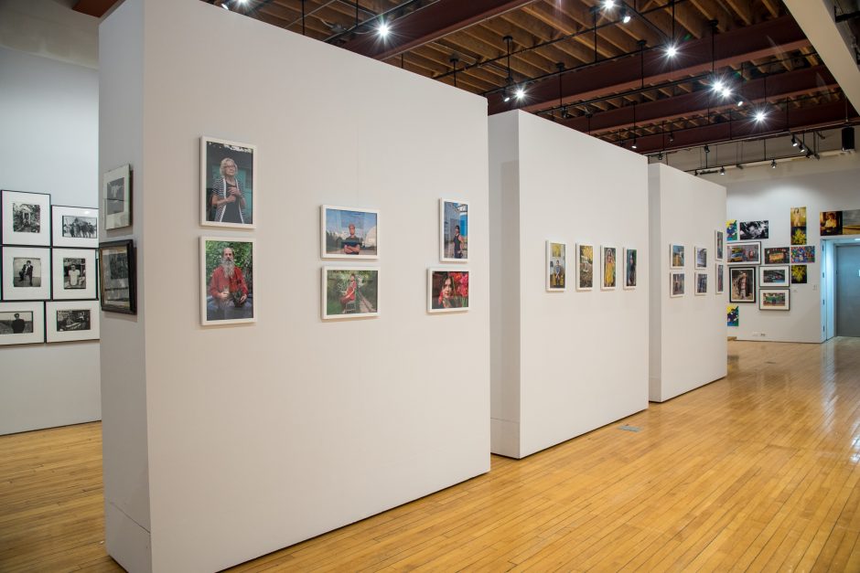 Several photos hanging on a wall in an art gallery