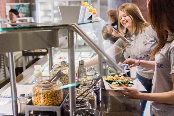 Two students fill their plates at the salad bar.