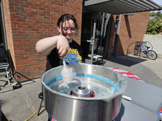 Student makes cotton candy for students during Ramapalooza.