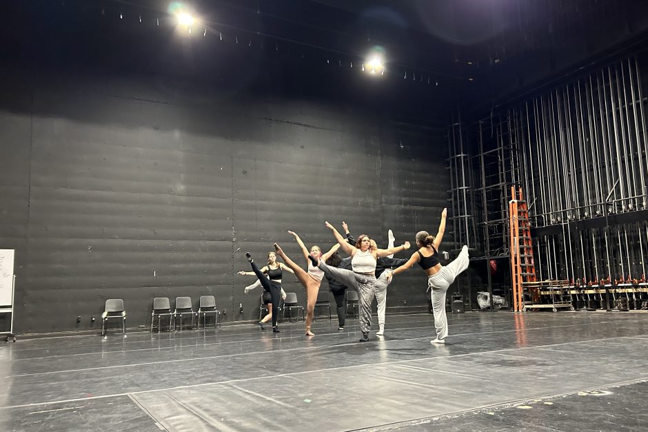 Several dancers hold a pose during a dance rehearsal.