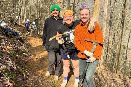 Taylor Busch ’24 and Audrey Pagel ’24, co-coordinators of Alternative Spring Break, and Sophia Perry ’24 (from left) take a break from building their small section of the Cumberland Trail.