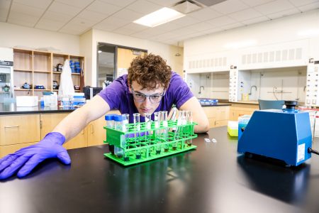 Callum McAllister ’24 demonstrates a Bradford assay, a lab technique he learned during his internship in a lab developing novel antibiotics to use against tuberculosis.