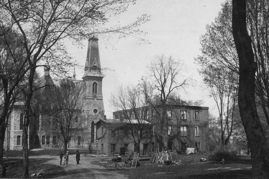 Old Sem, with damaged materials on the ground to its east, after the 1924 fire. King Chapel stands in the background.